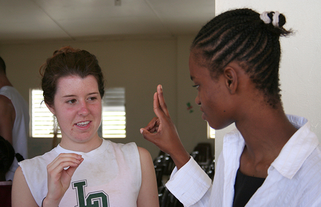 dos mujeres de secundaria utilizan el lenguaje de signos para comunicarse