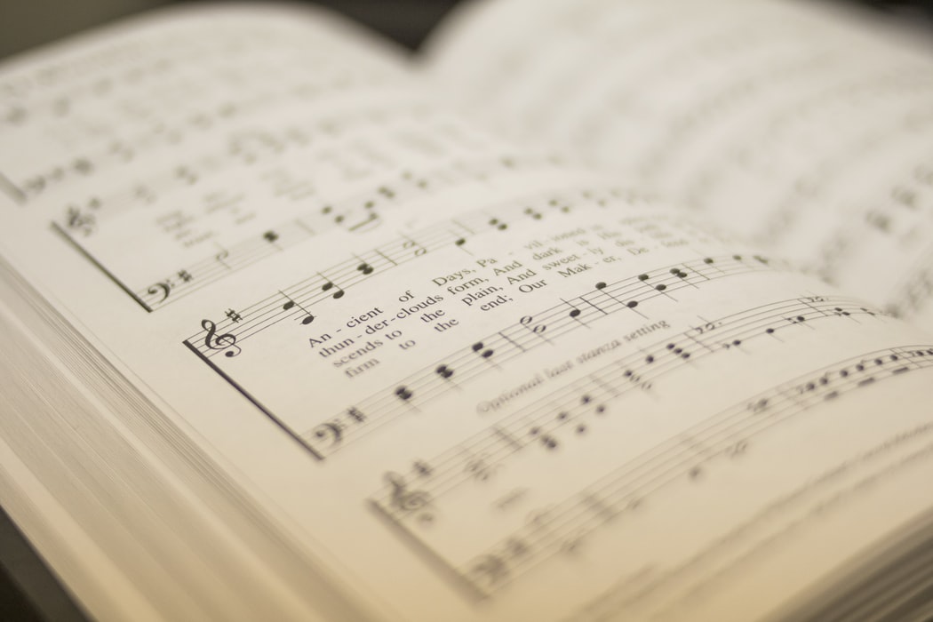 A close-up of a page in a hymn book with words and music.