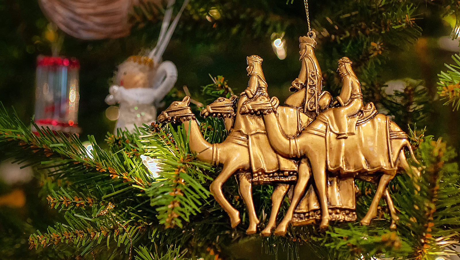 Christmas ornament of three wise men on camels hanging on Christmas tree