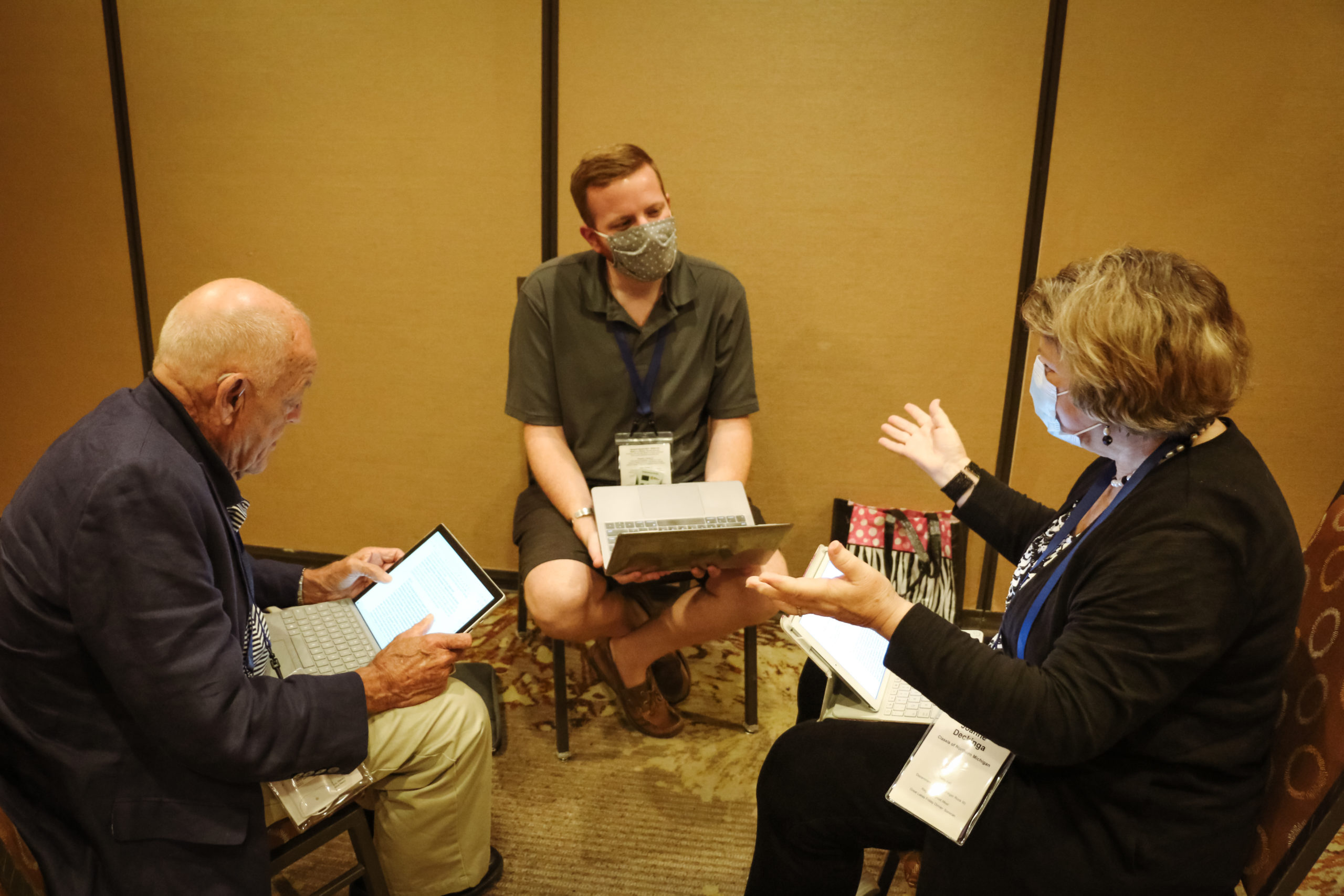 Three delegates engage in discussion during Thursday's discernment group time.