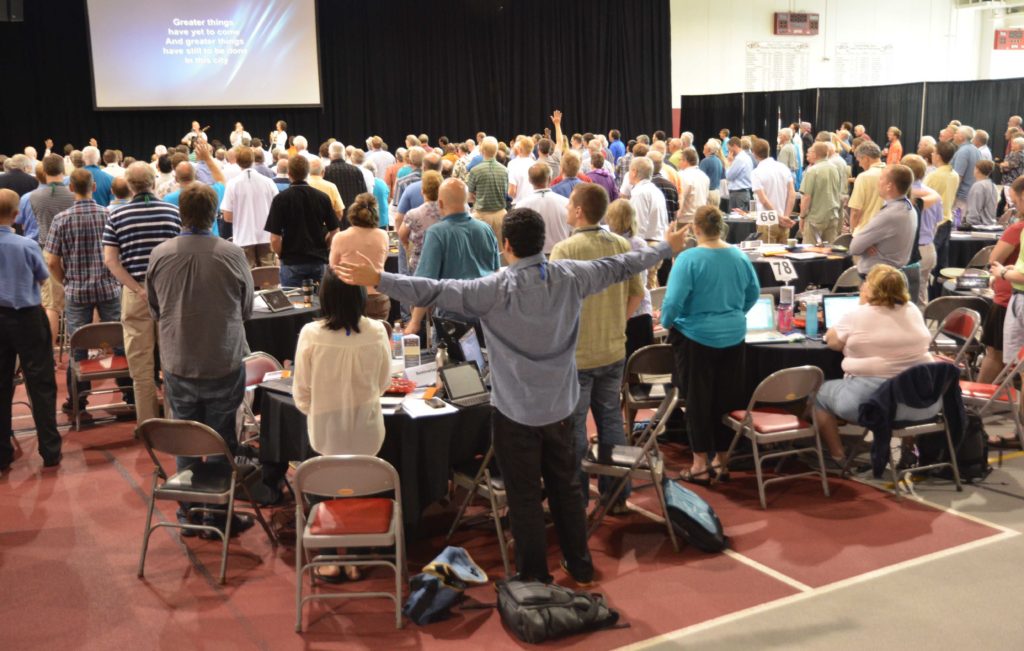 Delegates worshiping on the plenary floor of General Synod 2014