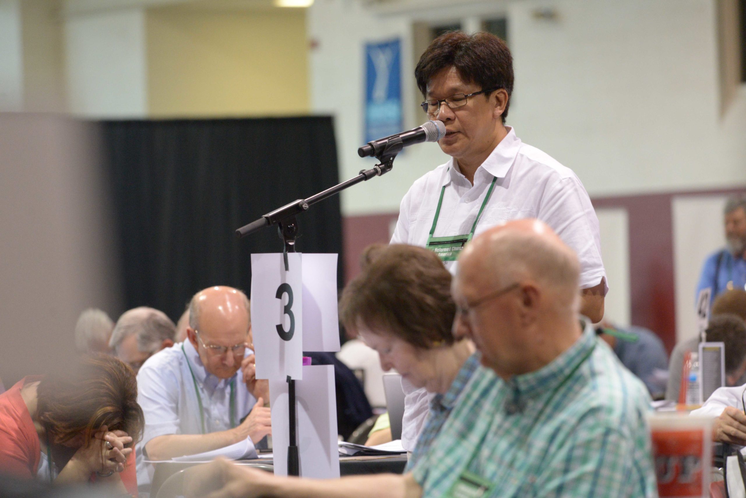 A delegate speaking at a mic during Genearl Synod 2014